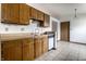 Kitchen with wooden cabinets, standard appliances, and tile flooring that connects seamlessly with adjacent spaces at 8016 Minlo Dr, Indianapolis, IN 46227