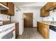 A functional kitchen featuring classic wood cabinetry and appliances, with tile flooring at 8016 Minlo Dr, Indianapolis, IN 46227