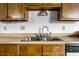 Close-up shot of the kitchen sink featuring stainless steel double basin sink with wood cabinets at 8016 Minlo Dr, Indianapolis, IN 46227