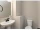 Clean, modern half bathroom with white pedestal sink, toilet, and towel rack at 1019 Cyprian Way, Lebanon, IN 46052