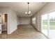 Bright dining area with hardwood floors, modern lighting, and sliding glass doors to backyard at 1019 Cyprian Way, Lebanon, IN 46052