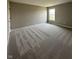 An empty bedroom with a window providing natural light, neutral colored walls, and carpeted floor at 12023 Crestwater Ct, Fishers, IN 46037