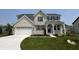 Beautiful two-story home with a well-manicured lawn, attached two car garage, and light colored brick at 12023 Crestwater Ct, Fishers, IN 46037