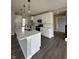 Modern kitchen featuring white cabinetry, a large island, stainless steel appliances, and luxury vinyl flooring at 12023 Crestwater Ct, Fishers, IN 46037