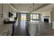 Open-concept kitchen with white cabinets, quartz countertops, and stainless steel appliances overlooking the living area at 12023 Crestwater Ct, Fishers, IN 46037