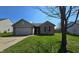 Charming single-story home features a brick facade, attached garage, and well-maintained lawn on a sunny day at 6024 Boulder Dr, Anderson, IN 46013