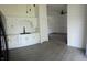 Bright kitchen featuring white cabinets, black fixtures, vinyl flooring and view into open-concept living room at 6024 Boulder Dr, Anderson, IN 46013