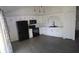 Modern kitchen with white cabinets, sleek black appliances, stylish backsplash, and grey vinyl floors at 6024 Boulder Dr, Anderson, IN 46013