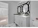 Bright bathroom showcasing tiled flooring, a dual sink vanity, a mirror, and a commode at 12997 Bartlett Dr, Fishers, IN 46037