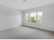 This is a light-filled bedroom with neutral-colored walls and carpeting, and a big window with a view at 12997 Bartlett Dr, Fishers, IN 46037