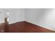 Simple bedroom with hardwood floors, white walls, and a closed door at 12997 Bartlett Dr, Fishers, IN 46037