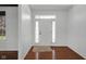 Bright foyer with hardwood floors, white walls, and a front door with glass inserts at 12997 Bartlett Dr, Fishers, IN 46037