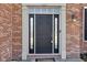 Elegant front door with sidelights and transom window, framed by brick and white trim at 12997 Bartlett Dr, Fishers, IN 46037