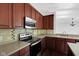 Well-equipped kitchen with wooden cabinets, modern appliances, and neutral countertops at 12997 Bartlett Dr, Fishers, IN 46037