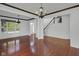 Large living room with hardwood floors, white trim, chandeliers, and a staircase at 12997 Bartlett Dr, Fishers, IN 46037