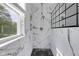 Modern shower with white marble walls, black tile flooring, glass door and shower head at 12997 Bartlett Dr, Fishers, IN 46037