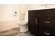 Bathroom with dark brown vanity, white toilet, and grey tile floor at 1684 Linden Ln, Greenfield, IN 46140