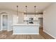 Open concept kitchen featuring a breakfast bar, stainless steel appliances, pendant lighting, and hardwood floors at 7370 Broadview Ln, McCordsville, IN 46055