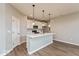 Modern kitchen featuring stainless steel appliances, quartz countertops, breakfast bar, pendant lights, and hardwood floors at 7370 Broadview Ln, McCordsville, IN 46055