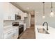 Bright kitchen featuring stainless steel appliances, quartz countertops, white cabinets, and modern fixtures at 7370 Broadview Ln, McCordsville, IN 46055
