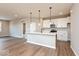 Open concept kitchen featuring a breakfast bar, stainless steel appliances, pendant lighting, and hardwood floors at 7370 Broadview Ln, McCordsville, IN 46055