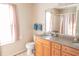 Bright bathroom featuring a double sink vanity, a wide mirror, and a shower with peach-colored curtains at 9563 England Ct, Noblesville, IN 46060