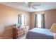 Comfortable bedroom with natural light, a ceiling fan, dresser and standard bed covered with light blue linens at 9563 England Ct, Noblesville, IN 46060
