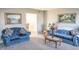 Inviting living room with plush blue couches, classic artwork, and a seamless flow to the dining area at 9563 England Ct, Noblesville, IN 46060