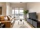 Living room featuring a large window, a comfortable sofa, modern furniture, and a TV on a media cabinet at 233 E Saint Joseph St # 3E, Indianapolis, IN 46202