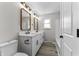 Modern bathroom with double vanity, updated fixtures, and stylish mirrors at 4445 Cherry Ln, Indianapolis, IN 46228