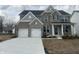 Charming two-story home featuring a mix of brick and stone, a two-car garage, and a welcoming front porch at 4958 Reavie Ct, Noblesville, IN 46062