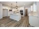 Modern kitchen featuring white cabinetry, a large island, and hardwood floors at 4958 Reavie Ct, Noblesville, IN 46062