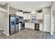 Modern kitchen with stainless steel appliances, white cabinets, gray countertops, and sleek hardwood floors at 7062 English Oak Dr, McCordsville, IN 46055