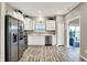 Modern kitchen with stainless steel appliances, white cabinets, gray countertops, and sleek hardwood floors at 7062 English Oak Dr, McCordsville, IN 46055