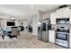 Open-concept kitchen with stainless steel appliances, white cabinets, and view into the dining and living areas at 7062 English Oak Dr, McCordsville, IN 46055