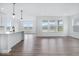 Bright open-concept living space with hardwood floors and large windows offering serene views at 16043 Meadow Frost Ct, Fishers, IN 46037