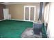 Living room with green carpet, brown walls, and a black wood-burning stove at 406 S Fenton Ave, Indianapolis, IN 46219
