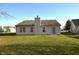 Spacious backyard with lush lawn and view of the home's rear exterior with windows and sliding glass door at 5250 Shamus Dr, Indianapolis, IN 46235