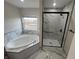 Modern bathroom featuring a soaking tub, and a walk-in shower with elegant marble-style tile at 13271 Lorenzo Blvd, Carmel, IN 46074