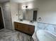 Bathroom featuring a double vanity with marble counters and modern fixtures, along with a soaking tub at 13271 Lorenzo Blvd, Carmel, IN 46074