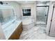 Bathroom featuring a double vanity with marble counters, modern fixtures, tub, and separate shower at 13271 Lorenzo Blvd, Carmel, IN 46074