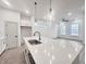 Bright kitchen with stainless steel sink in center island, pendant lights, white cabinets, and modern appliances at 537 Gilder Dr, Carmel, IN 46032
