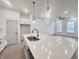 Bright kitchen with stainless steel sink in center island, pendant lights, white cabinets, and modern appliances at 537 Gilder Dr, Carmel, IN 46032