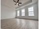Spacious main bedroom with wood floors, three large windows, tray ceiling, and a ceiling fan at 537 Gilder Dr, Carmel, IN 46032