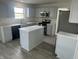 Modern kitchen includes an island, stainless appliances, gray cabinets, pantry and sleek countertops at 6936 W Briarwood Blvd, New Palestine, IN 46163