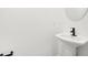 Modern half-bathroom features a pedestal sink with black faucet and white walls at 20397 Hudson Bay Ln, Westfield, IN 46074