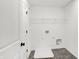 Practical laundry room with overhead shelving, tiled floors, and washer/dryer hookups at 20397 Hudson Bay Ln, Westfield, IN 46074