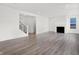 Bright living room with modern staircase with black railing, fireplace, and a window providing natural light at 20397 Hudson Bay Ln, Westfield, IN 46074
