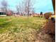 Expansive backyard featuring a well-maintained lawn, mature trees, shed, and chain link fence at 4619 Mac Dr, Anderson, IN 46013