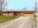 Charming one-story brick home featuring an attached one-car garage and a long driveway at 4619 Mac Dr, Anderson, IN 46013
